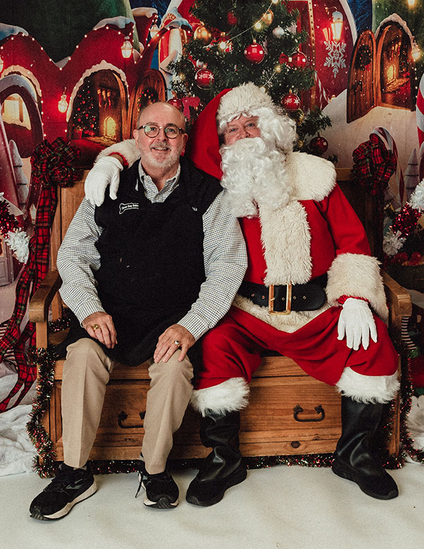 Santa Claus 2022 with dogs sitting next to shop owner